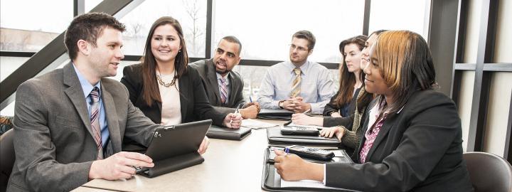 A diverse group at a table in business attire